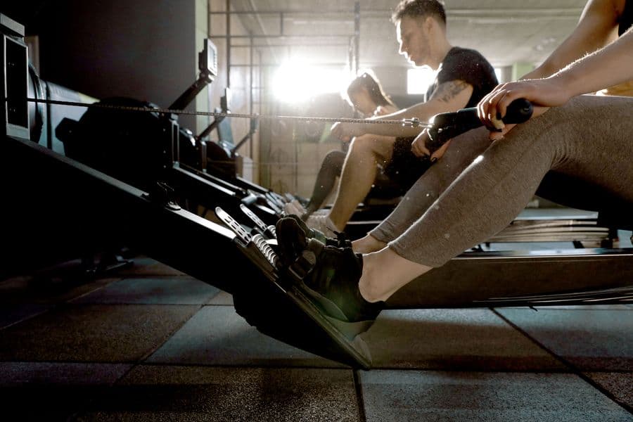 Athletes rowing on a machine during a HYROX training session in Boston.
