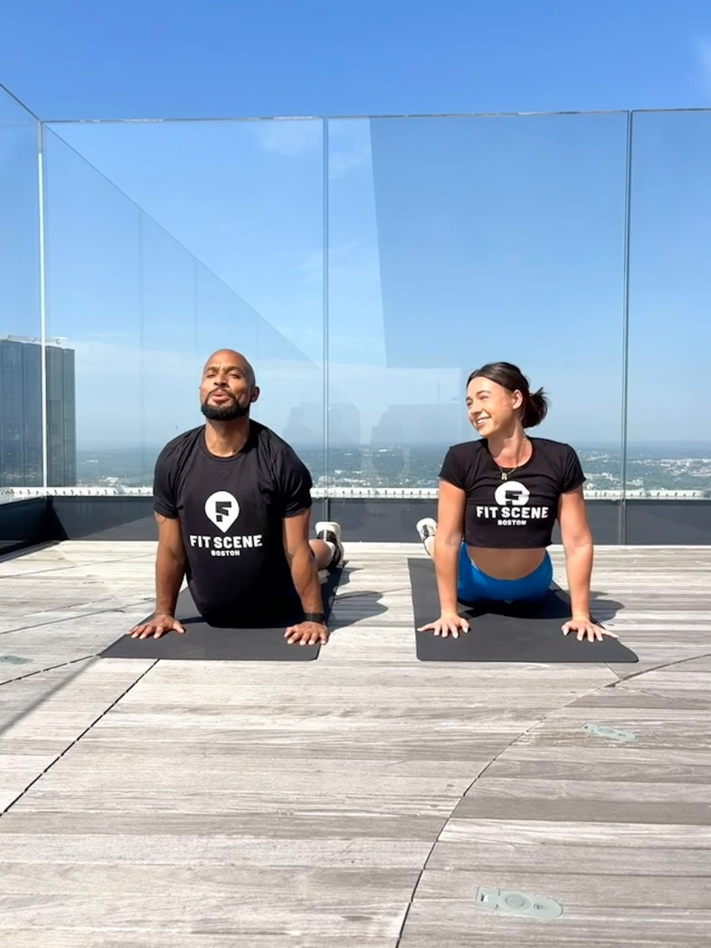 Rylee Abbott and Adrian Bispham, instructors leading Fit Scene Boston and View Boston's Rooftop Wellness Series kickoff event.